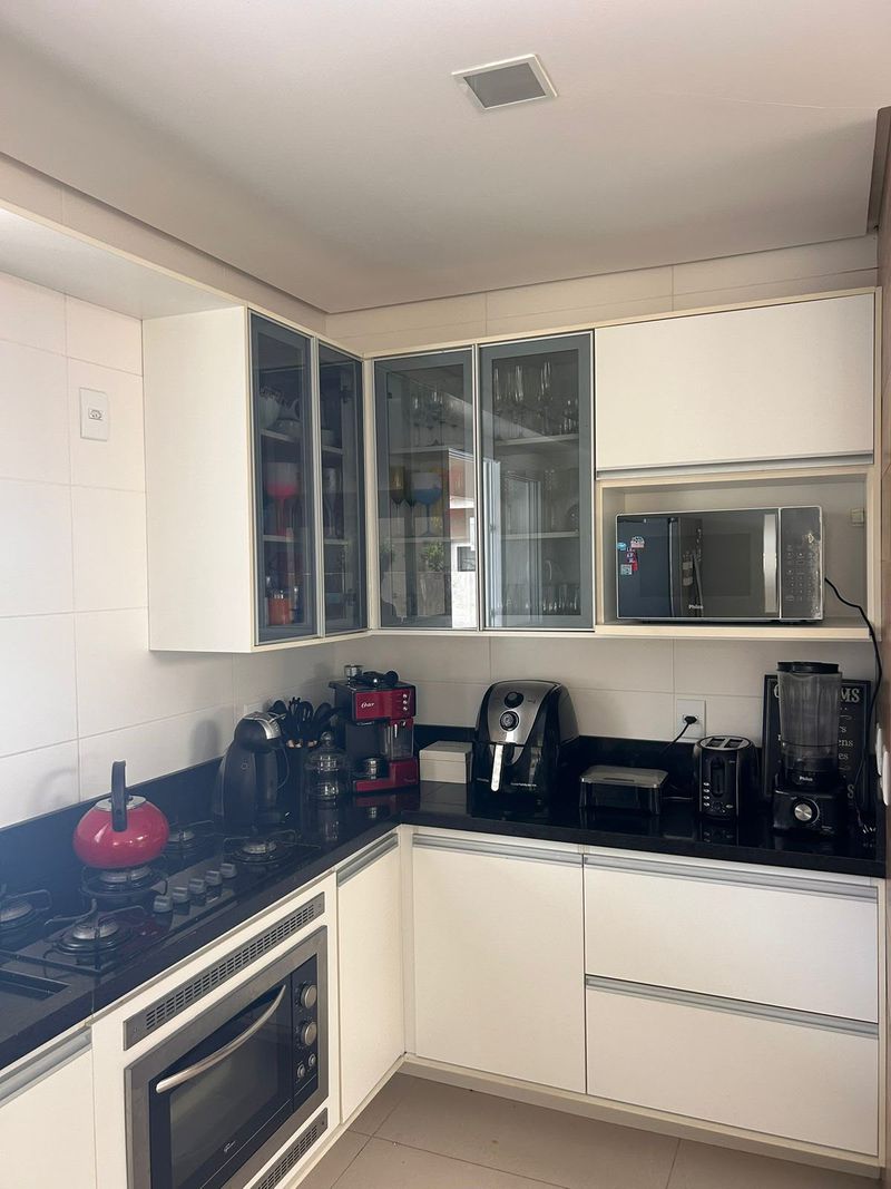 Cozinha em L com cooktop, forno elétrico, micro-ondas, air fryer e cafeteira