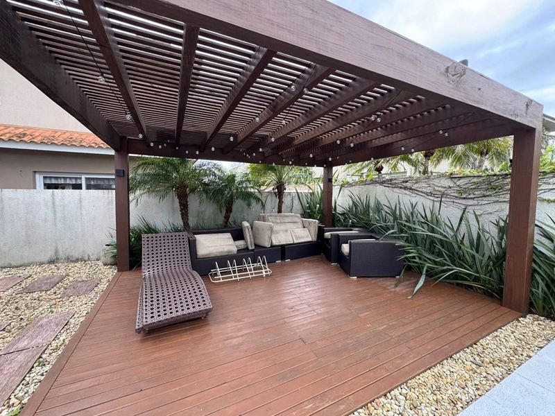 Lounge sob o pergolado de 30 m² com sofás e espreguiçadeira