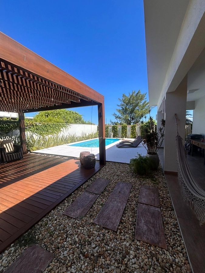 Pergolado de madeira e piscina em um dia de céu azul